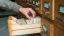 Ein Mann greift in die geöffnete Schublade eines alten Karteikartenschranks.